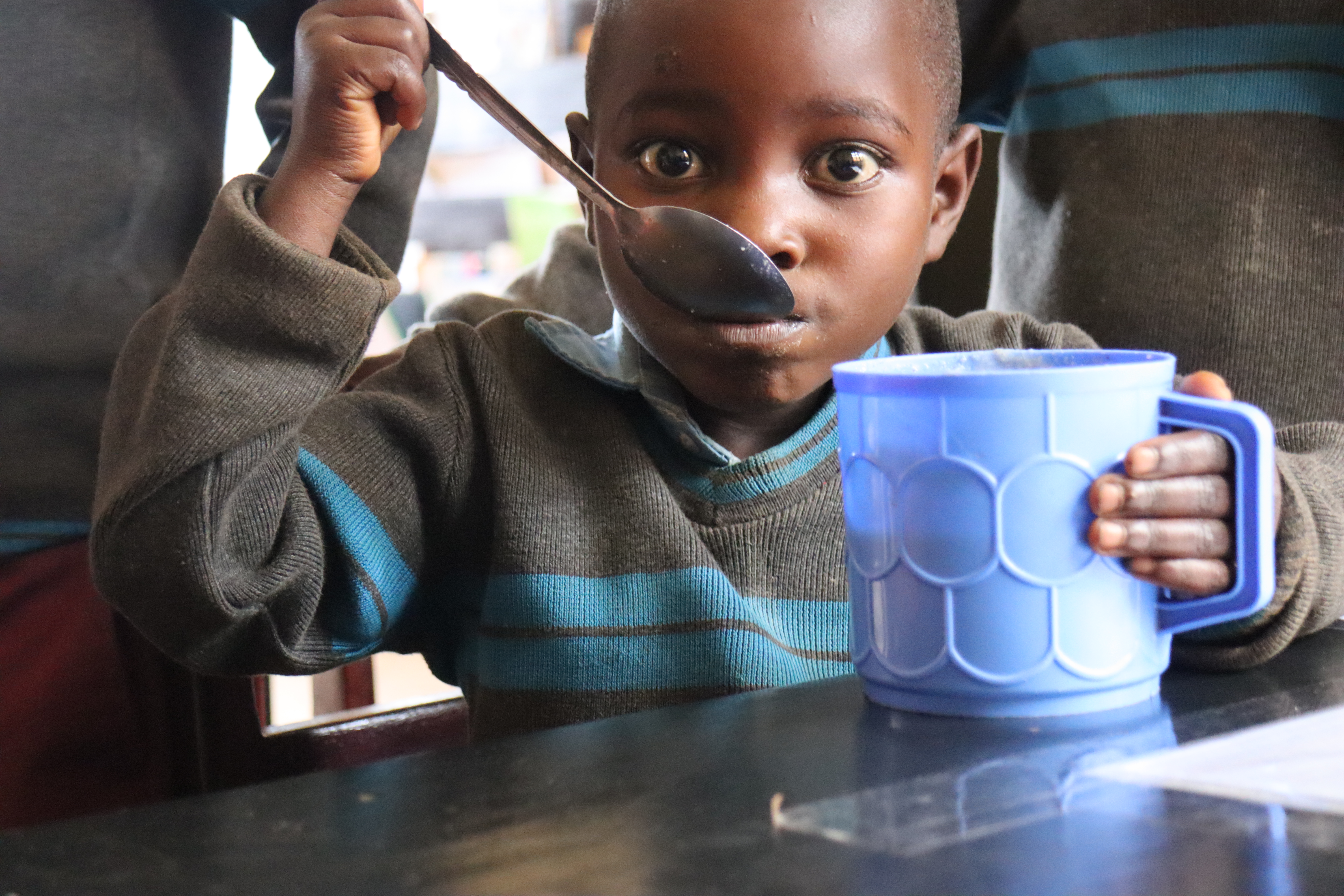 child eats porridge at school feeding program programme Burundi