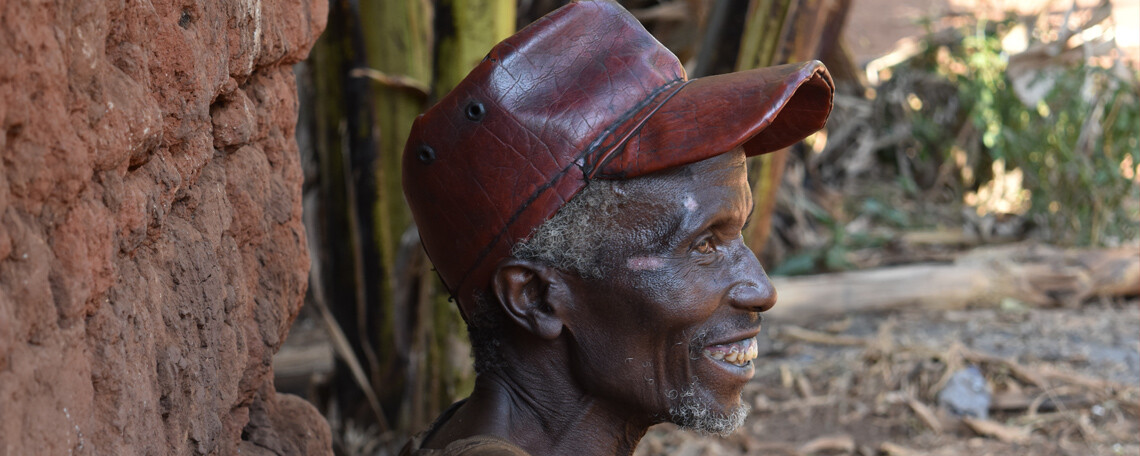 a UCCD beneficiary smiling in front of his house