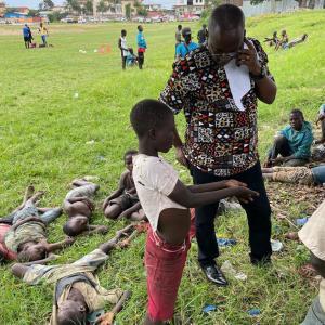 Thierry on the grass with other street-connected children